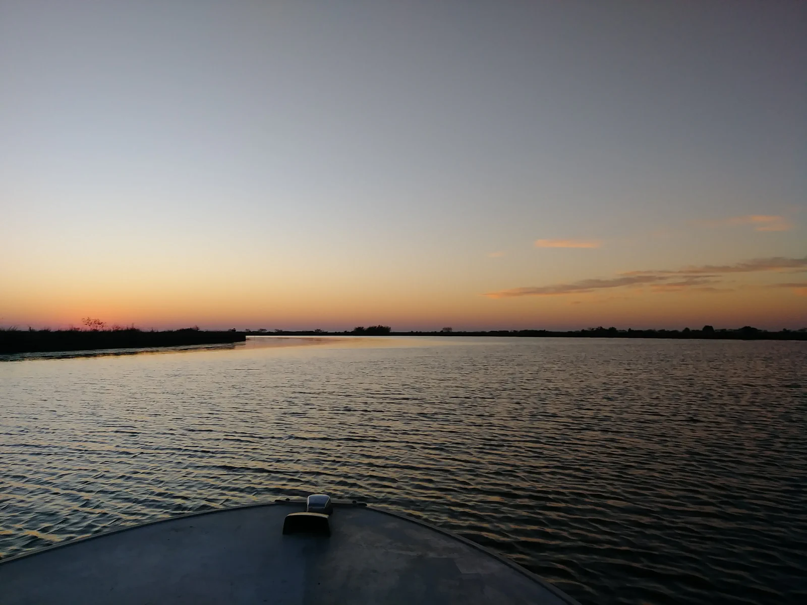 Open Southeast Louisiana water with marsh edges at sunrise