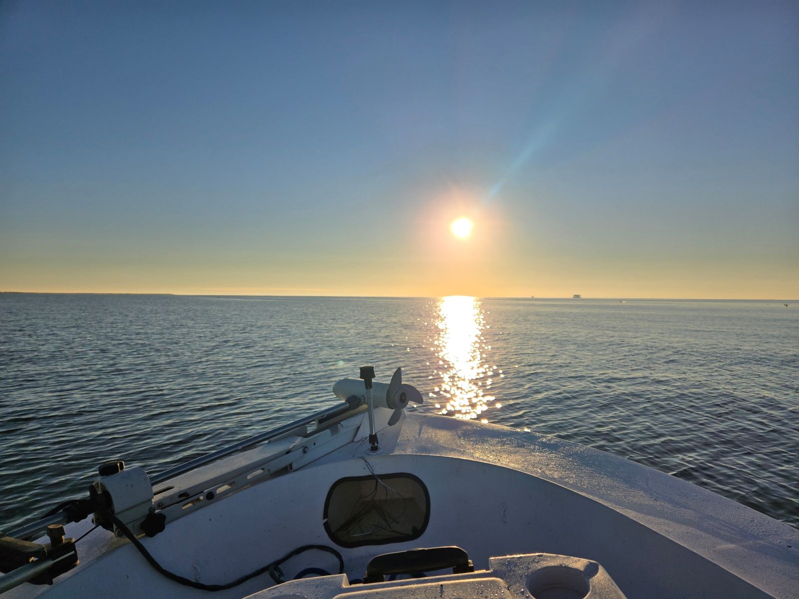 Boat bow facing calm South Louisiana water at sunrise